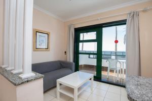 a living room with a couch and a table at Apartamentos Olympia in Playa del Ingles