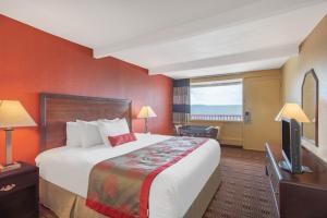 a hotel room with a bed and a flat screen tv at Ramada Limited Cockeysville in Cockeysville
