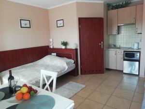 mały pokój z łóżkiem i stołem z owocami w obiekcie Zachód Słońca Mielno w mieście Mielno
