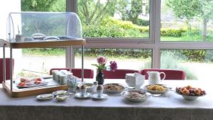 una mesa con platos de comida en ella con una ventana en Auberge du Cabestan Hotel Audierne, en Audierne 29 fotos más