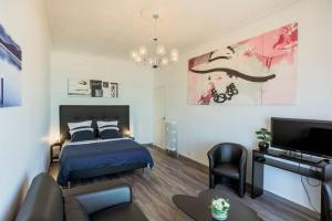 a bedroom with a bed and a couch and a tv at SEA FRONT SUITE - Panoramic View with Terrace - 85 m in Nice
