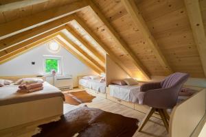 a attic bedroom with two beds and a chair at Modern and Cozy little House Mia in Dugopolje +29 photos