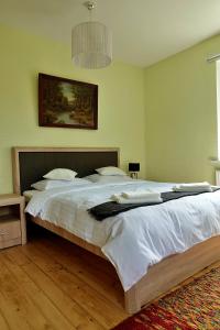 a bedroom with a large bed with white sheets at Krusttēvu māja in Sigulda