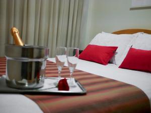 um quarto de hotel com uma cama com dois copos numa bandeja em Icaraí Praia Hotel em Niterói