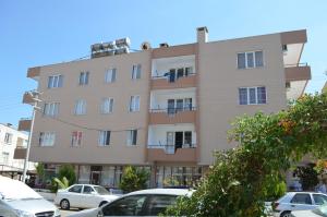 a building with cars parked in front of it at Ahmeda Apart Hotel in Ayvalık