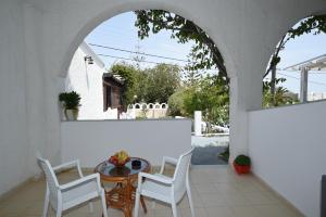 a patio with a table and chairs and an archway at Sunflower ApartHotel in Kamari