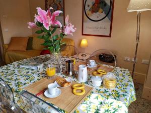 a table with breakfast foods and a vase of flowers at Apartment in Molino Stucky in Venice