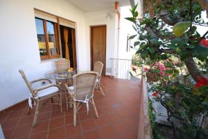 a patio with a table and chairs and a plant at B&B Villa Rosa in Cefalù
