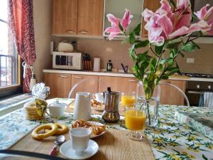 a kitchen table with a vase of flowers and orange juice at Apartment in Molino Stucky in Venice