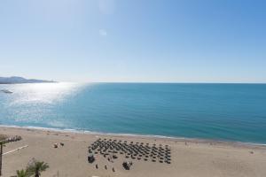 eine Gruppe von Menschen am Strand mit dem Meer in der Unterkunft MalagaSuite Malagueta Impressive Views in Málaga