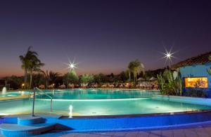 a large swimming pool at night with lights at Hotel Santa Chiara in Capo Vaticano