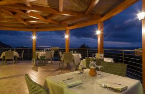 a restaurant with tables and chairs on a balcony at Hotel Santa Chiara in Capo Vaticano