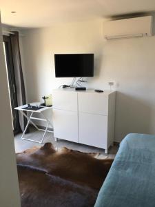 una sala de estar con un armario blanco con TV. en La Luna, en Sóller