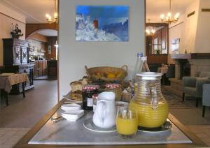 una mesa con una jarra de zumo y vasos. en Auberge du Cabestan Hotel Audierne, en Audierne