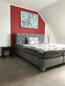 1 dormitorio con 1 cama grande y pared roja en Hotel Maxdorfer Hof en Maxdorf