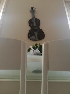 a guitar and flowers on a table with a chair at Casa Eva 2010 in Cremona