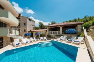- une piscine avec des chaises et une maison dans l'établissement Apartments Villa Elena 3, à Cavtat