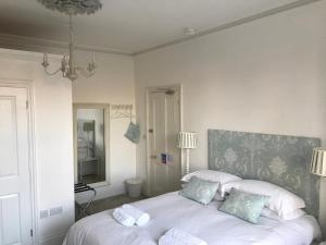 a bedroom with a white bed with two pillows at Poplars Farm in Henlow