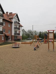 einen Spielplatz mit Spielgeräten vor einem Gebäude in der Unterkunft Apartament Mierzeja in Sztutowo