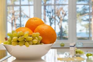 a bowl of oranges and grapes on a table at Direkt am Strand mit Meerblick und Sauna - FeWo Strandidyll in Binz