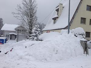 una pila de nieve delante de una casa en Pensjonat Kasia i Michał en Szklarska Poręba