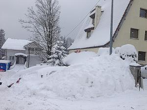 una pila de nieve delante de una casa en Pensjonat Kasia i Michał, en Szklarska Poręba