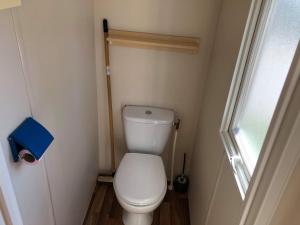 Elle comprend une petite salle de bains pourvue de toilettes et d'une fenêtre. dans l'établissement Camping Horizon Bar, à Frontignan