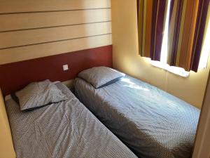 a small bedroom with two beds and two windows at Camping Horizon Bar in Frontignan