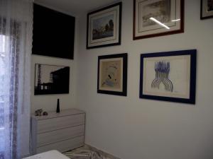 um quarto com quadros na parede e uma cómoda em Casa dei limoni em Catânia