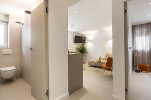 a bathroom with a toilet and a living room at Park Residence in Split