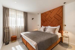 a bedroom with a large bed with a wooden headboard at Park Residence in Split