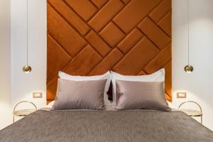 a bed with a large wooden headboard and two pillows at Park Residence in Split