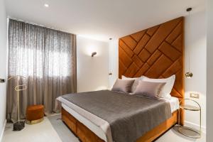 a bedroom with a large bed with a wooden headboard at Park Residence in Split