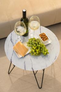 a table topped with wine glasses and cheese and grapes at Park Residence in Split