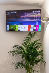 a flat screen tv hanging on a wall with a plant at Park Residence in Split