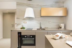 a kitchen with white marble walls and a sink at Park Residence in Split