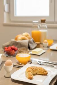 a table with a plate of bread and orange juice at Park Residence in Split