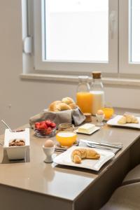 a breakfast table with pastries and orange juice and oranges at Park Residence in Split