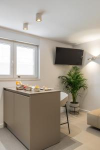 a kitchen with a island with a tv on the wall at Park Residence in Split