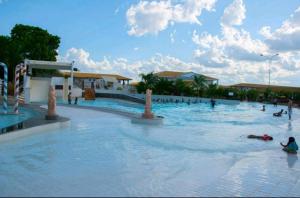 a group of people swimming in a swimming pool at Park L'acqua di roma - Cozinha completa in Caldas Novas