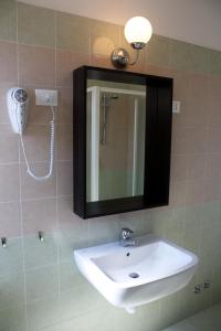 bagno con lavandino e specchio di Hotel Helga a Caorle