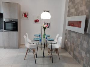 a dining room with a glass table and white chairs at Vonitsa Loft Apartment 2 in Vonitsa