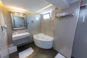 a white bathroom with a sink and a toilet at Demi Hotel in Sarandë