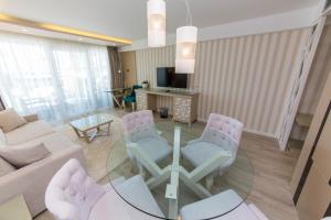 a living room with a glass table and chairs at Demi Hotel in Sarandë