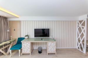 a room with a desk and a tv on a wall at Demi Hotel in Sarandë