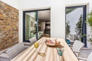 un tavolo in legno con 2 bicchieri da vino su un patio di Villa Colibri a La Croix-Valmer