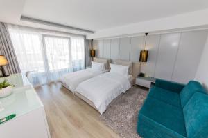 a bedroom with a white bed and a blue couch at Demi Hotel in Sarandë