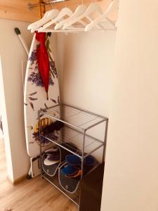 a room with a surfboard and a rack with shoes at Family or Group Apartment in Silent Center in Riga