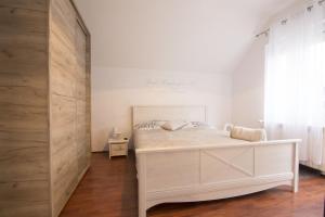 a bedroom with a white bed and a window at Dolce Casa in Belgrade