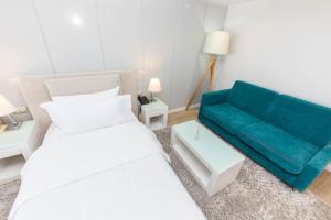 a bedroom with a bed and a blue couch at Demi Hotel in Sarandë